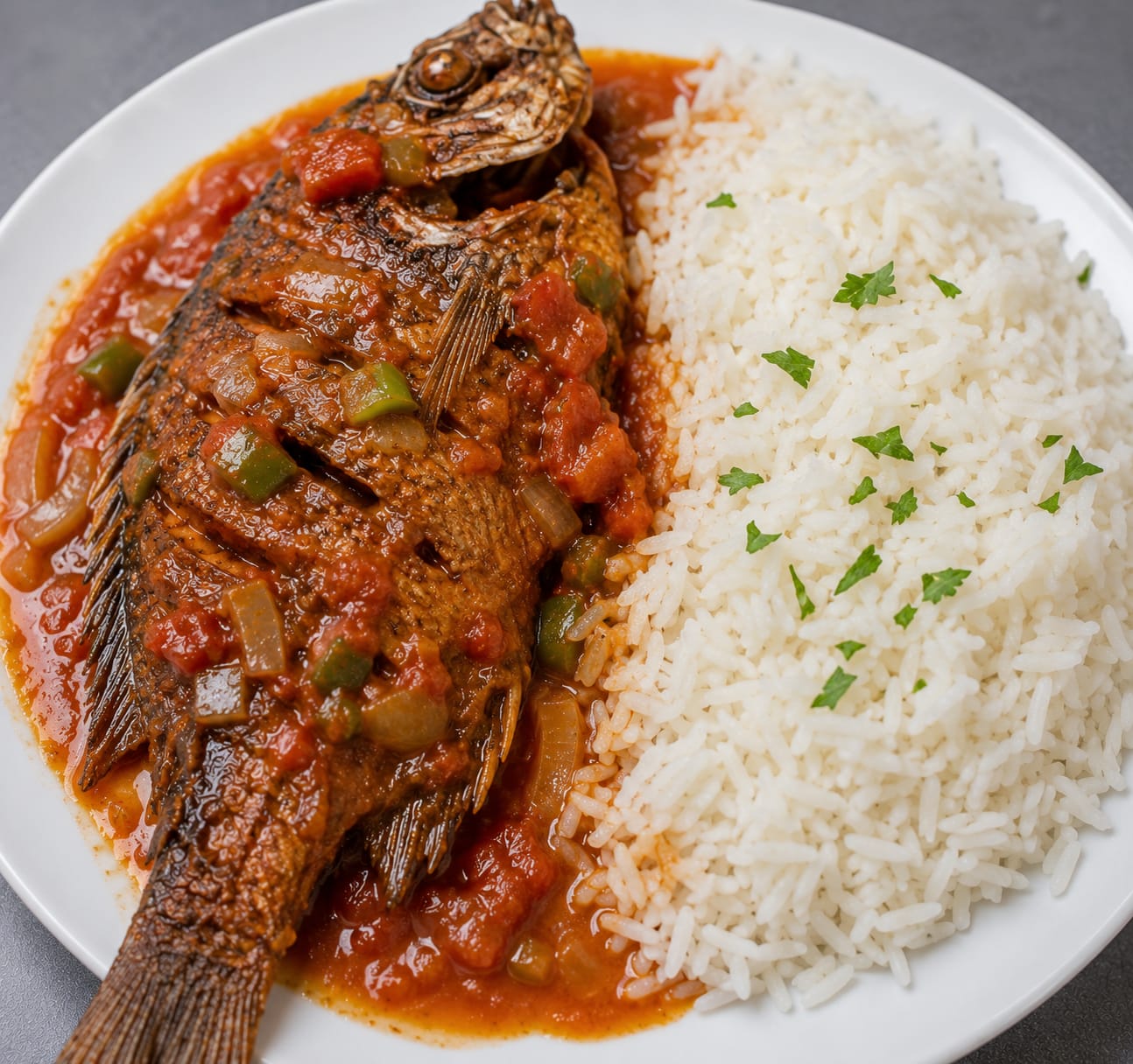 Wet fried tilapia fish meal with rice on the side
